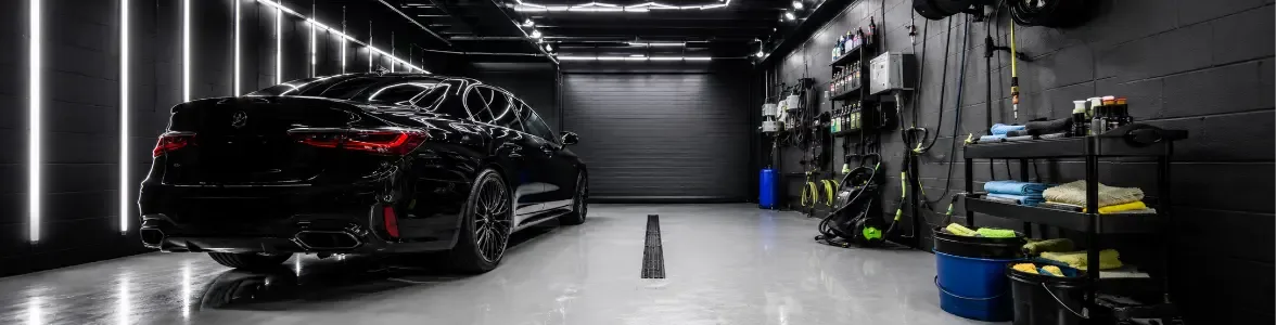 Black performance car inside a fully equipped indoor valet bay available for hire in Norwich